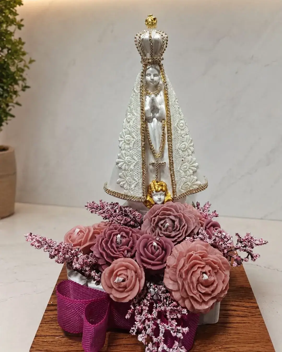 Estátua coroada com arranjo floral em tons de rosa