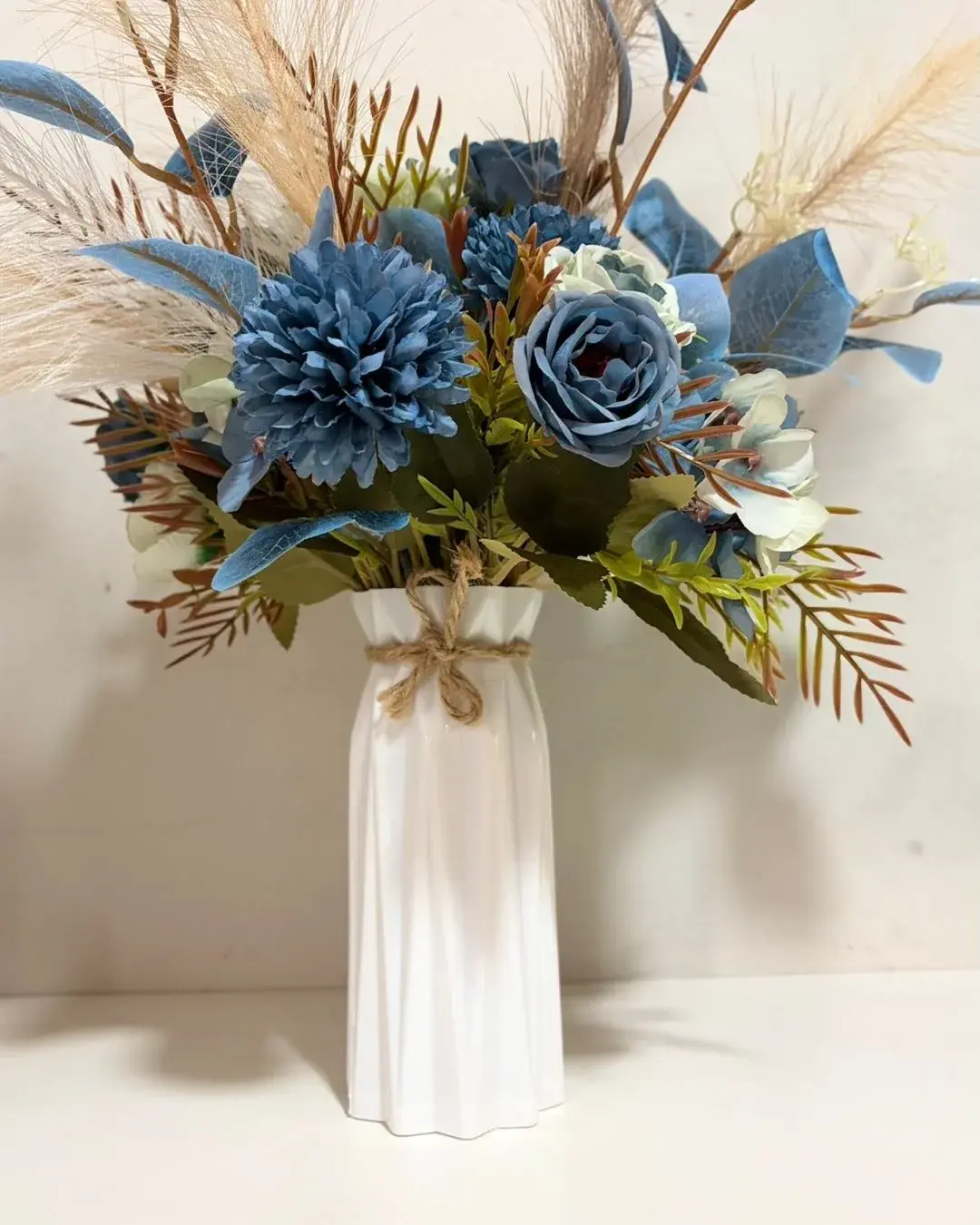 Arranjo de flores azuis em vaso branco